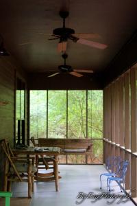 un porche cubierto con banco y ventilador de techo en The Meadow Cabin en Folsom