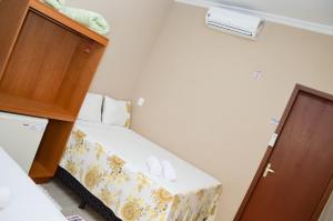 um pequeno quarto com uma pequena cama e um armário em Pousada Pouso Vitoria em Pirenópolis