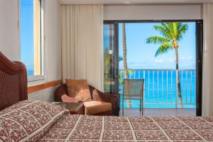 a bedroom with a bed and a view of the ocean at Ka'anapali Beach Hotel in Lahaina