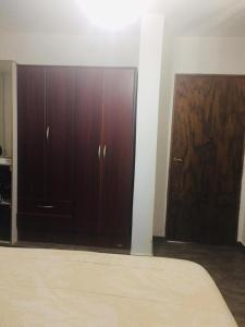 1 dormitorio con 1 cama y 2 armarios de madera en Benito Soria 137 en Santa Rosa de Calamuchita