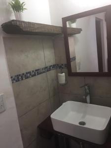 y baño con lavabo blanco y espejo. en Benito Soria 137 en Santa Rosa de Calamuchita