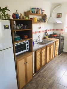 eine Küche mit Spüle und Mikrowelle in der Unterkunft Benito Soria 137 in Santa Rosa de Calamuchita