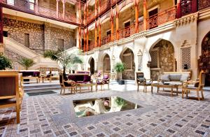 a lobby with a fountain in the middle of a building at Shah Palace Luxury Museum Hotel in Baku