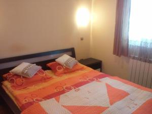 プレデアルにあるApartament Alinのベッドルーム1室(オレンジと白のキルトのベッド1台付)