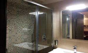 uma casa de banho com um chuveiro, um lavatório e um espelho. em La Ginestra Affittacamere em Ginosa
