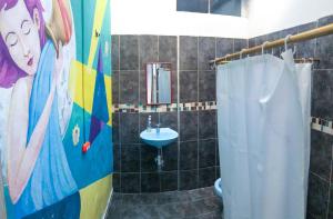 a bathroom with a shower and a sink and a shower curtain at JEP Hostel in Medellín