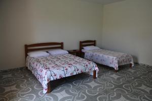 A bed or beds in a room at Pousada Recanto Das Garças