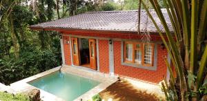 a small house with a swimming pool in front of it at Tea Leaf Retreat in Kandy