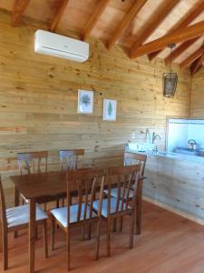 a dining room with a table and chairs and a kitchen at Emunah in Punta Del Diablo