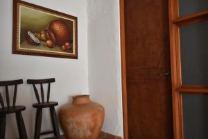 un vase assis à côté d'une peinture de fruits sur un mur dans l'établissement Hospedaje Don Juan, à Barichara