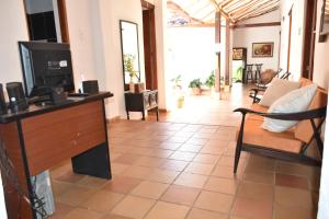 a living room with a television and a couch at Hospedaje Don Juan in Barichara