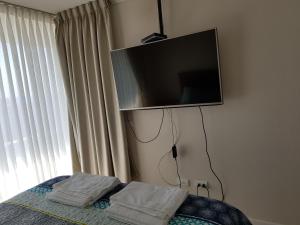 una camera da letto con TV a schermo piatto a parete di Departamento Bora Bora a La Serena