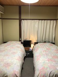 two beds sitting next to each other in a bedroom at Aigakusou in Nozawa Onsen