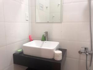a bathroom with a white sink and a mirror at Ruby Dalat Hostel in Da Lat