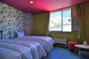 a hotel room with two beds and a window at HOTEL 24sweets HAKUBA in Hakuba