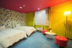 HOTEL 24sweets HAKUBA في هاكوبا: غرفة نوم بسريرين وطاولة وكراسي