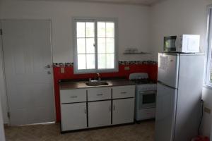 uma cozinha com um frigorífico branco e um lavatório em Bed and Breakfast Little Italy em Boquerón