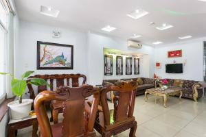 a living room with wooden chairs and a couch at Tuan Long Hotel in Ho Chi Minh City