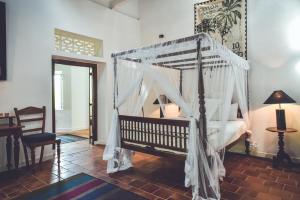a bedroom with a bed with a canopy at Templeberg in Galle