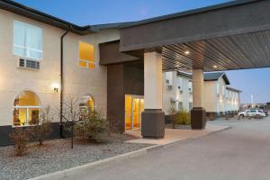 un edificio con un estacionamiento delante de él en Days Inn & Suites by Wyndham Thompson en Thompson