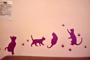 a wall with cats and birds stencils on it at Yellow Cat B&B in Taitung City