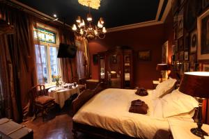 a bedroom with a bed and a dining room with a table at B&B De Lachende Engel in Mechelen