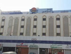 a large building with a sign on top of it at Dolphin Hotel in Muscat