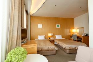 una camera d'albergo con due letti e una tv di Hotel Grand Vert Gizan a Gifu