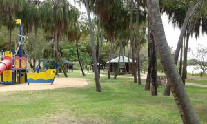 um parque infantil num parque com palmeiras em Reef Suite em Agnes Water