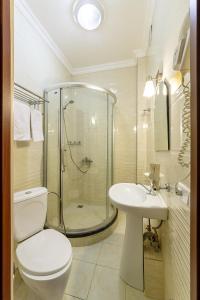 a bathroom with a shower and a toilet and a sink at Renion Zyliha Hotel in Almaty