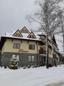 a large building with snow in front of it at Apartmán Plesnivec in Donovaly