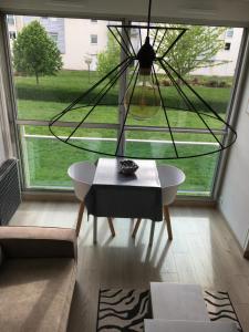 a living room with a table and a large window at Cosylocation La Varende 71 in Rennes