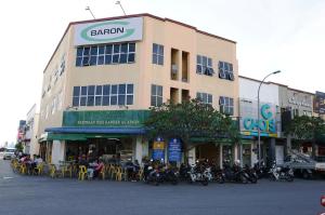 a large building with motorcycles parked in front of it at 1 Baron Motel in Kuah