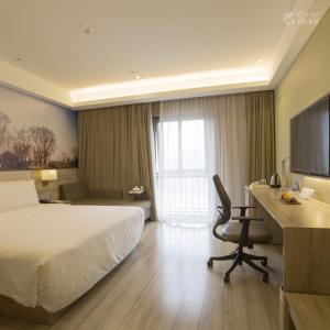 een hotelkamer met een bed en een bureau met een computer bij Atour Hotel Hangzhou Xixi Zijingang in Hangzhou
