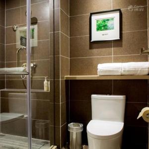 een badkamer met een toilet en een glazen douche bij Atour Hotel Hangzhou Xixi Zijingang in Hangzhou