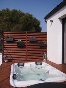 a hot tub sitting on a patio with a fence at L'ESCALE COTE BLEUE B&B AND Spa in Sausset-les-Pins