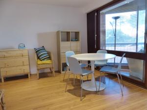 uma sala de jantar com uma mesa e cadeiras e uma janela em Appartement 2 personnes vue sur le port #0278 em Soorts-Hossegor