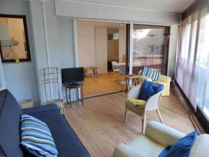 uma sala de estar com um sofá e cadeiras e uma televisão em Appartement 2 personnes vue sur le port #0278 em Soorts-Hossegor