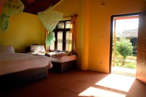 een slaapkamer met 2 bedden en een groot raam bij Nature Safari Resort in Bhurkīā