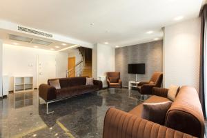 een woonkamer met banken en stoelen en een televisie bij The Loft House Taksim in Istanbul