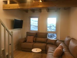 uma sala de estar com um sofá e uma televisão em Ginebra Deluxe Domus em Sierra Nevada