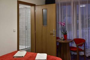 a bedroom with a bed and a table and a door at Willa Anna Maria in Białka Tatrzanska