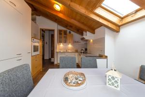 uma cozinha e sala de jantar com uma mesa com uma pizza em Apartments Haus Martin em Nova Levante