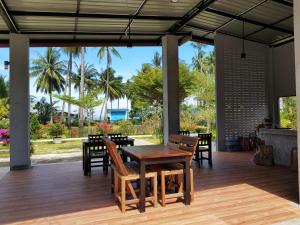 a wooden table and chairs on a patio at Mook Ing Lay in Ko Mook