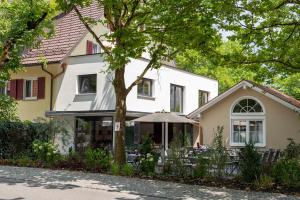 ein weißes Haus mit einem Regenschirm davor in der Unterkunft Boutique - Hotel Zum Schloss in Amtzell
