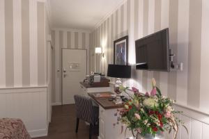 a hotel room with a desk with a tv on the wall at Europa Hotel Kühlungsborn in Kühlungsborn
