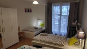 1 dormitorio con 2 camas y ventana en Apartman 404 en Jáchymov