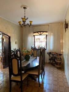 a dining room with a wooden table and chairs at Bertioga Paradise in Bertioga