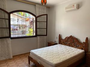 a bedroom with a bed and a large window at Bertioga Paradise in Bertioga