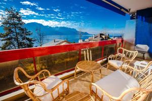 un grupo de sillas y mesas en un balcón en Terrace with Lake & Mountain View, en Montreux